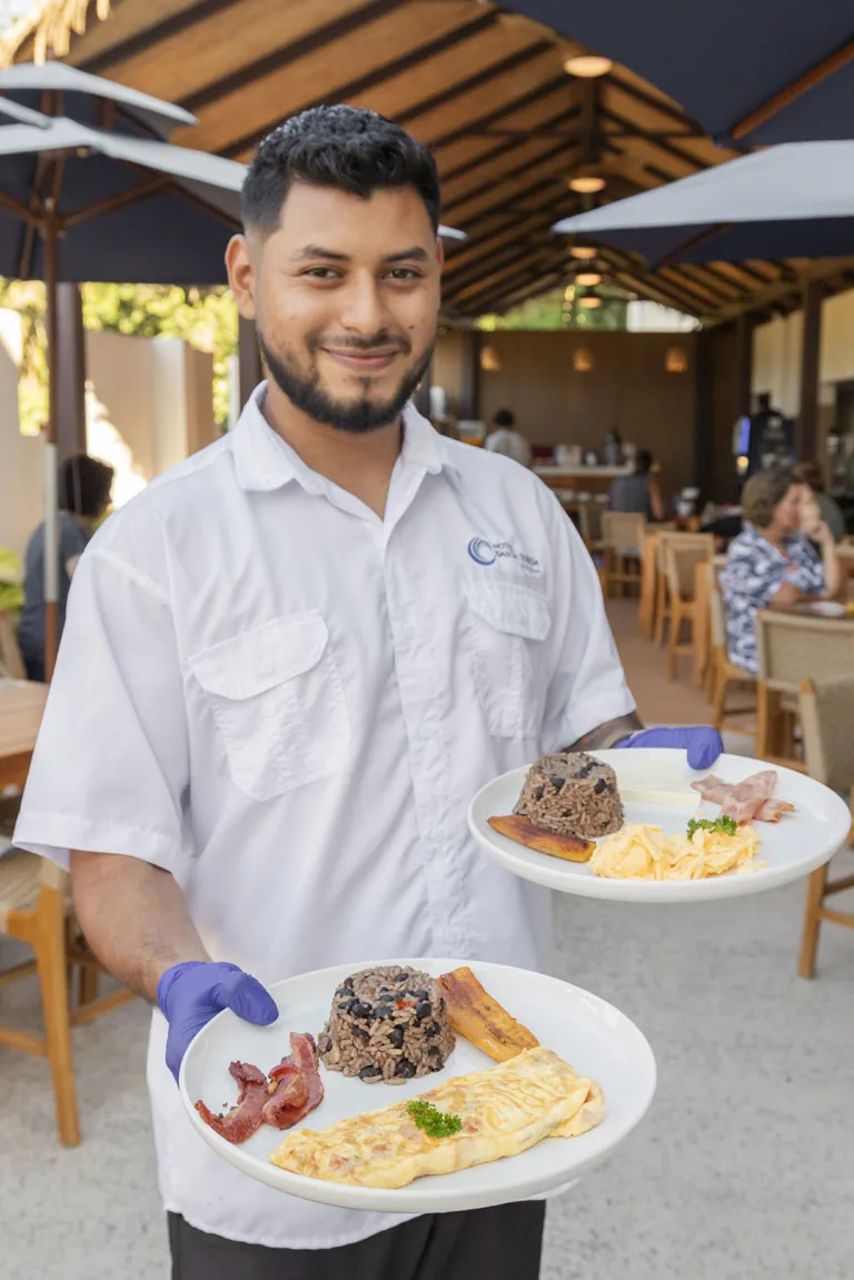 Waiter serving breakfast plates