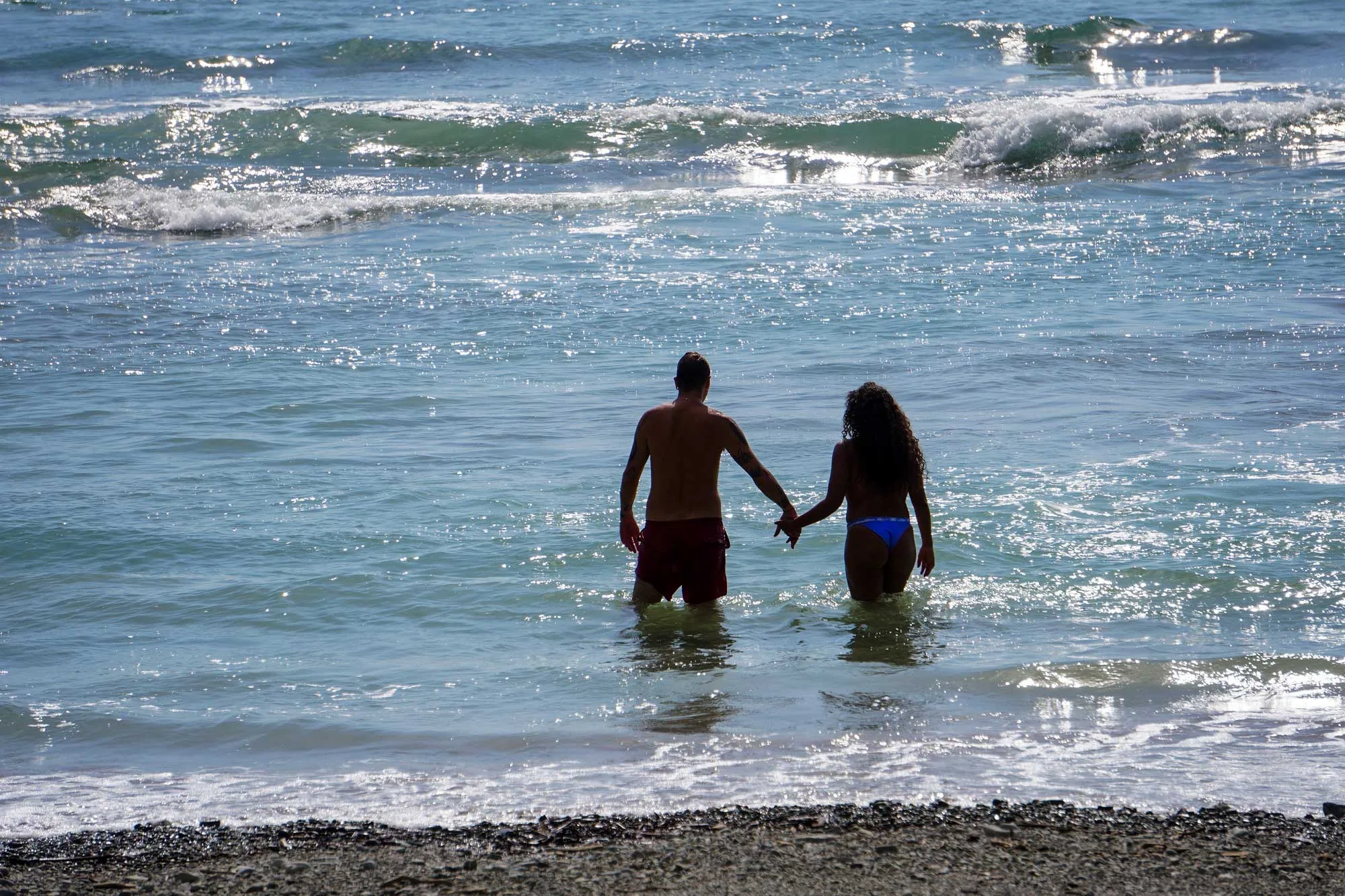 Couple walking into the ocean